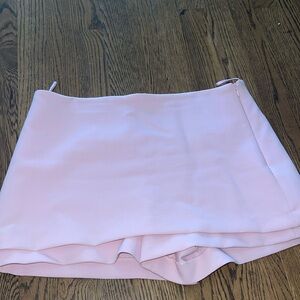 Low-rise skort. False back welt pockets. Side hidden in-seam zip closure